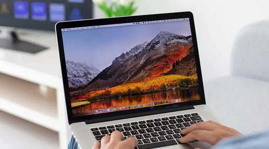 Customer reviewing MacBook Pro condition before buying at PayMore Sand Lake
